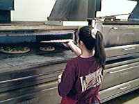 Sliding the pizza into the oven